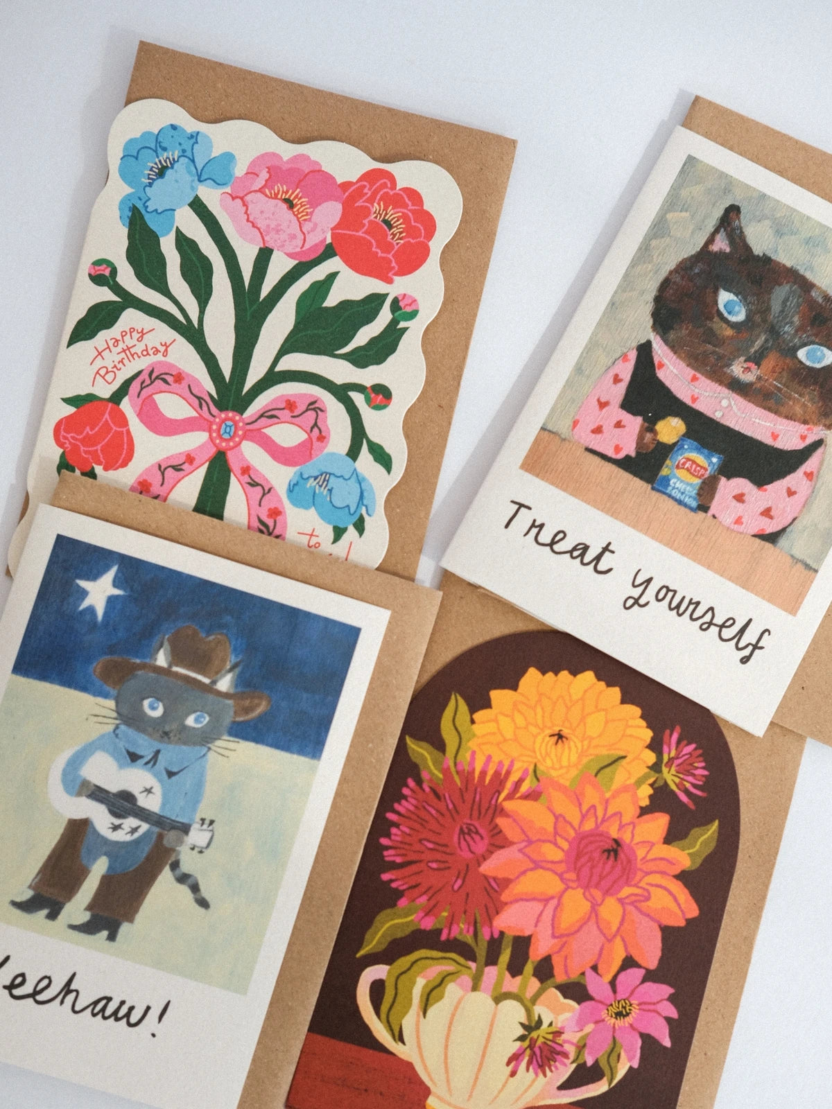 Four greeting cards with different designs on a white background