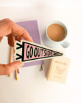 Hand holding a 'GO OUTSIDE' sticker with a cup of coffee and stationery in the background