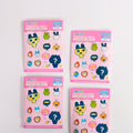 Four packages of Tamagotchi character keyrings on light gray background
