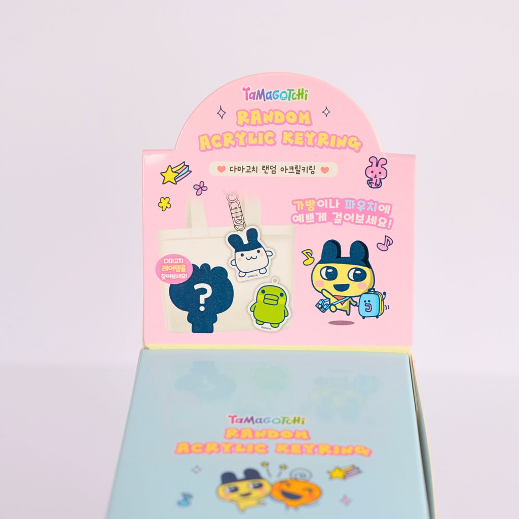TaMagochi acrylic keyring packaging with colorful characters on a light gray background