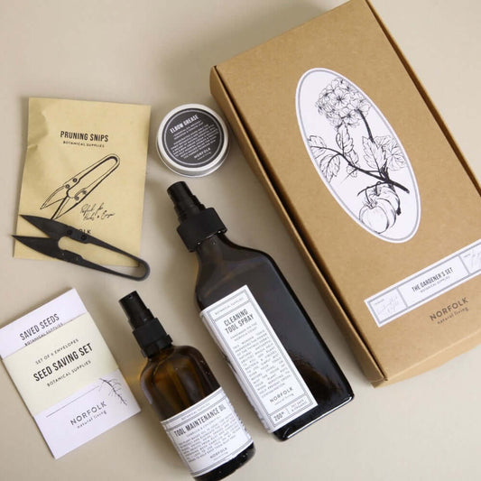 Collection of natural gardening products including bottles, a box, and packets on a beige background