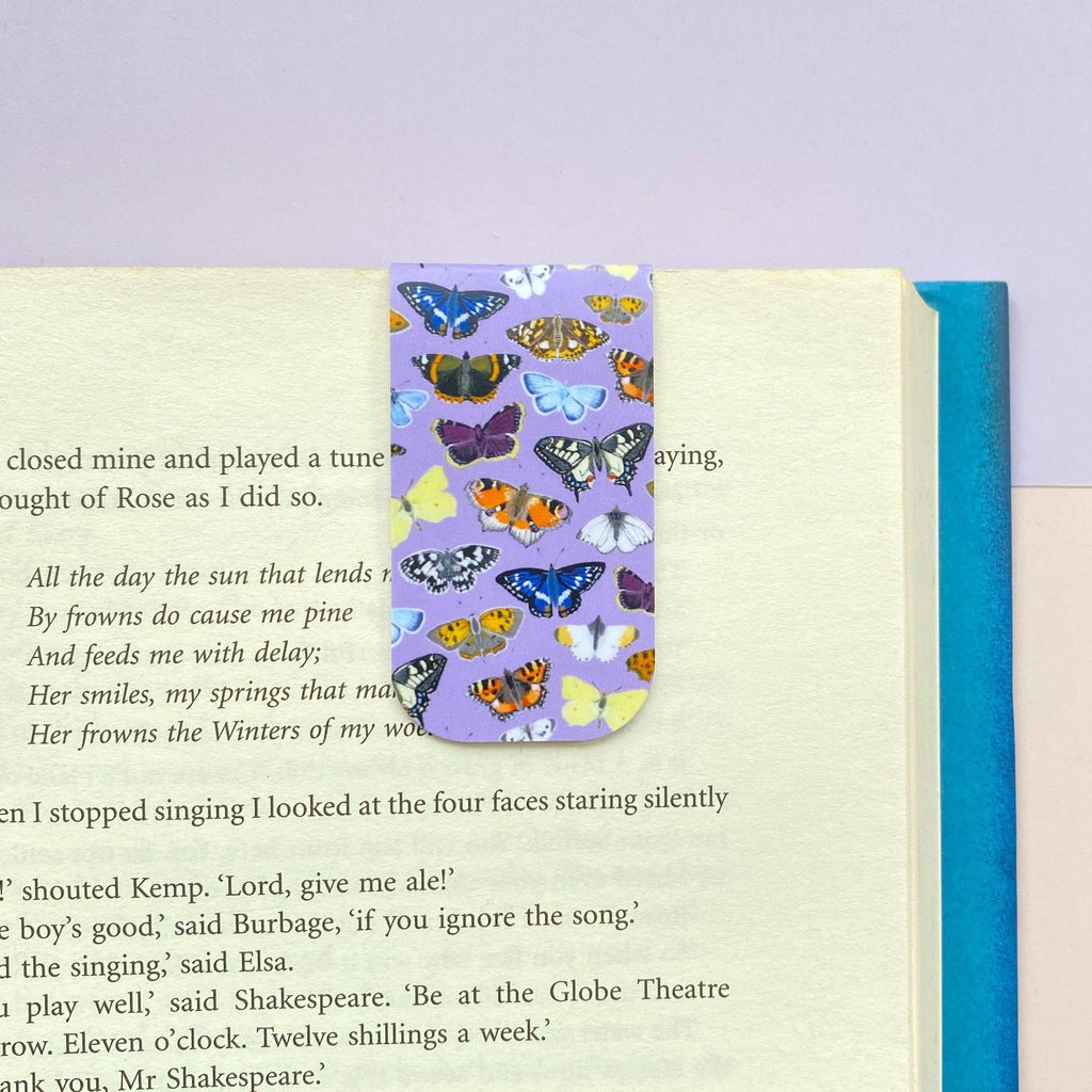 Butterfly patterned bookmark on an open book with a purple background