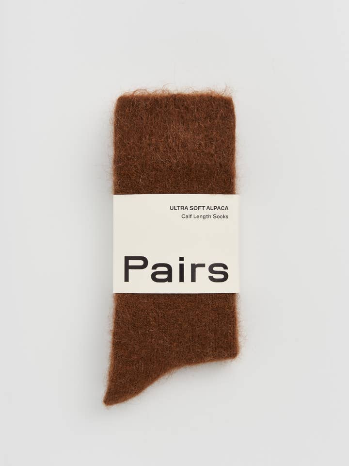 Brown sock with a 'Pairs' label on a light gray background