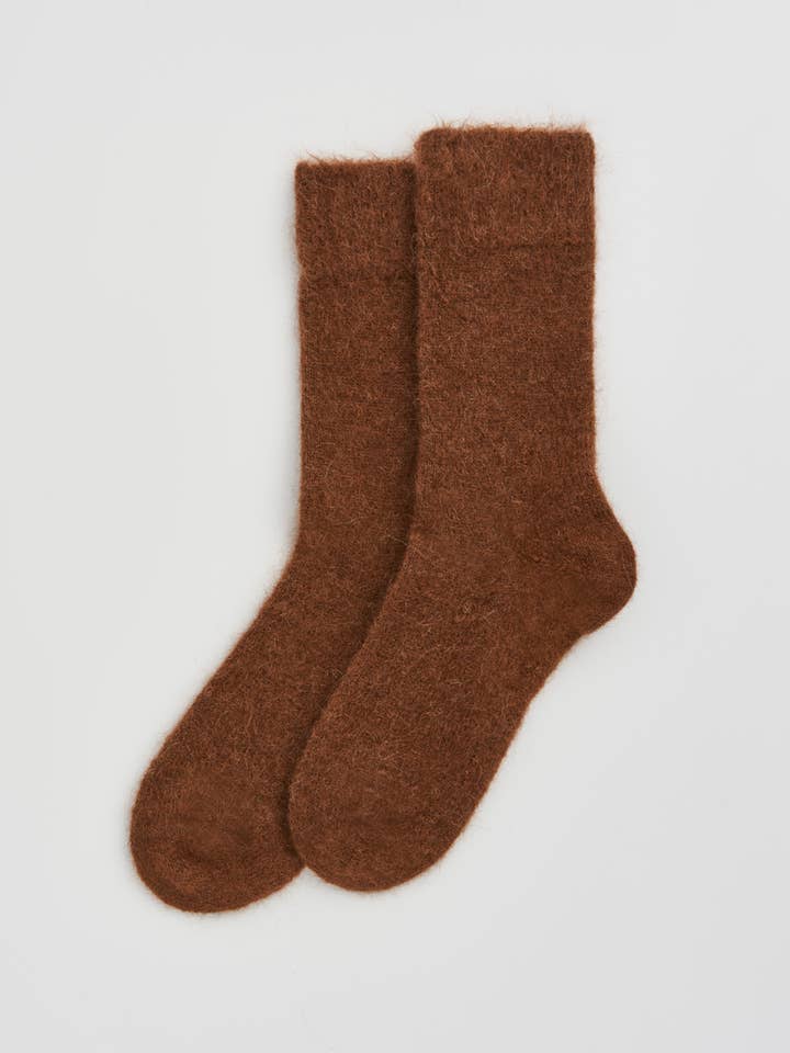 Pair of brown socks on a light gray background