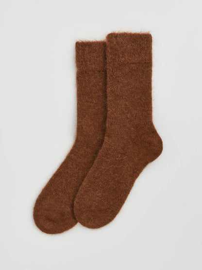 Pair of brown socks on a light gray background