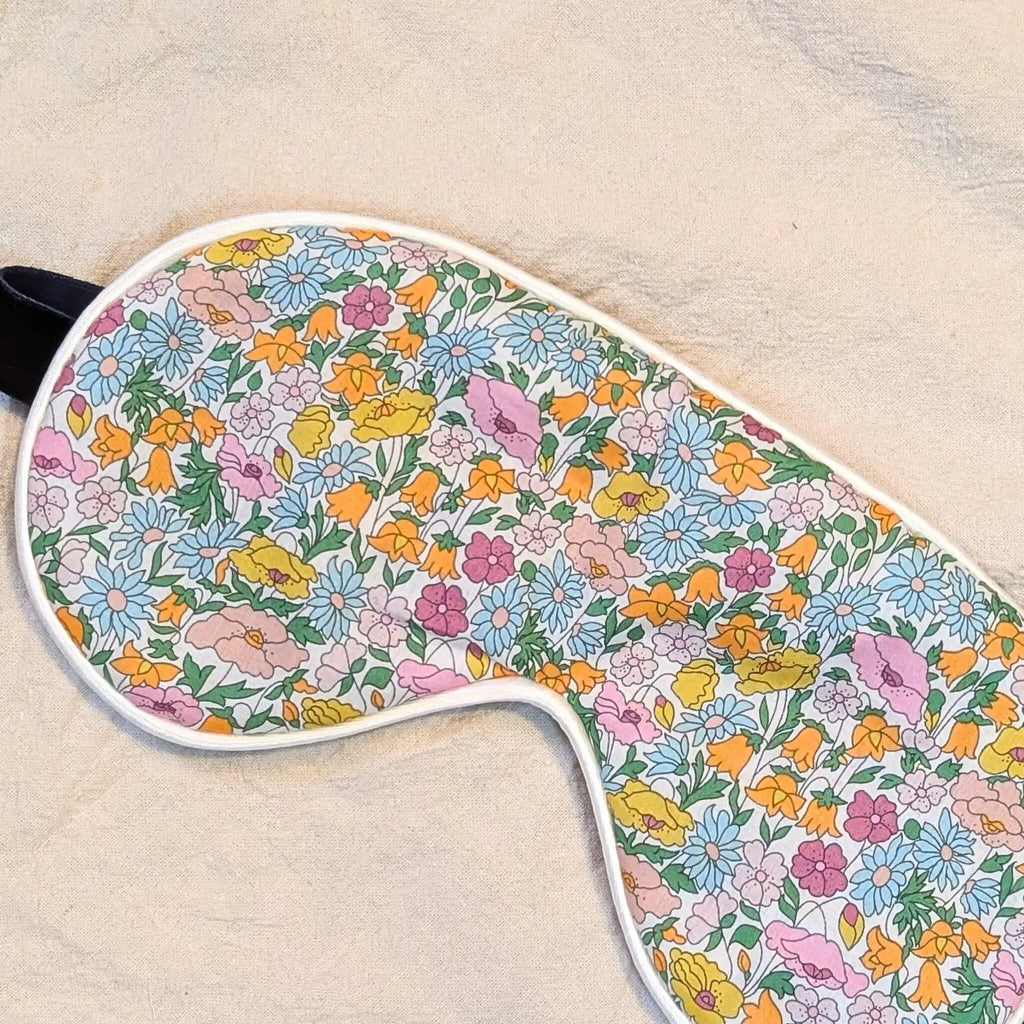 Floral-patterned eye mask on a beige background