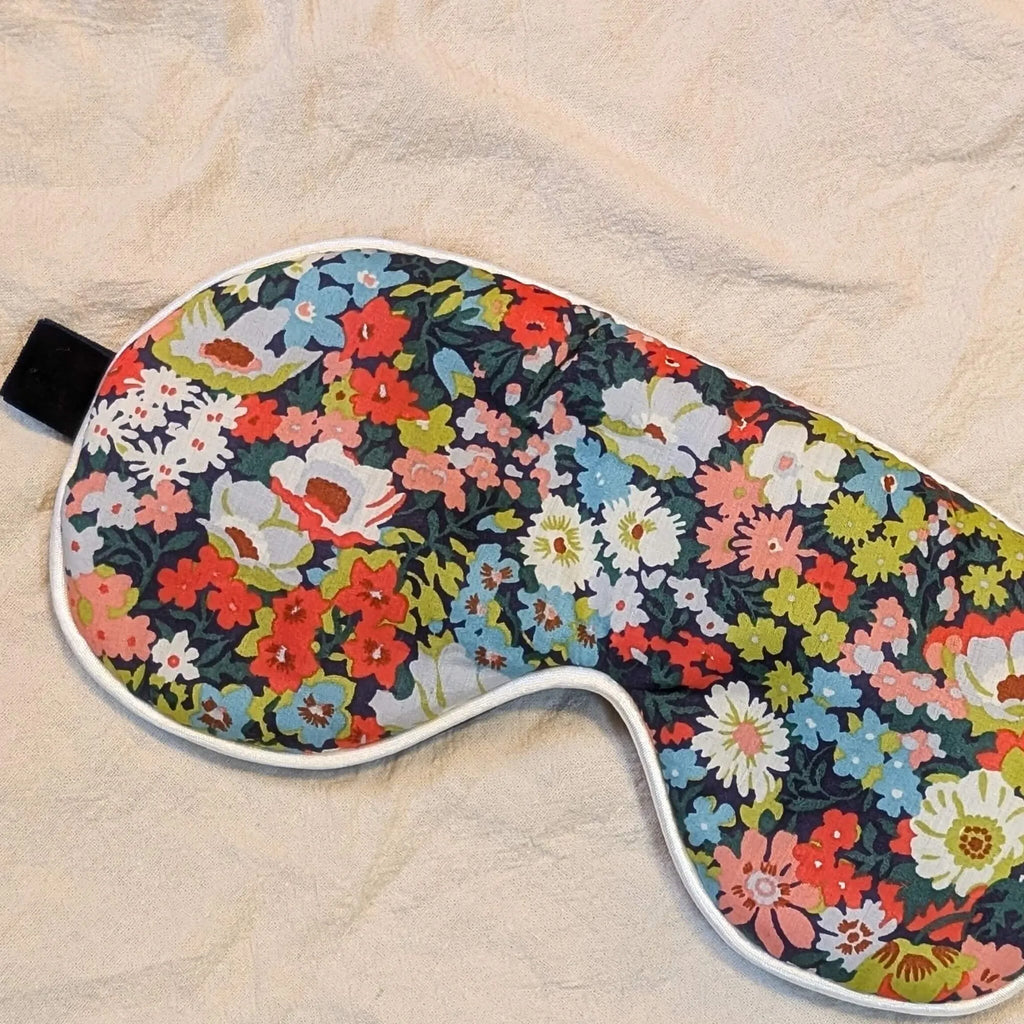 Floral patterned eye mask on a beige fabric background