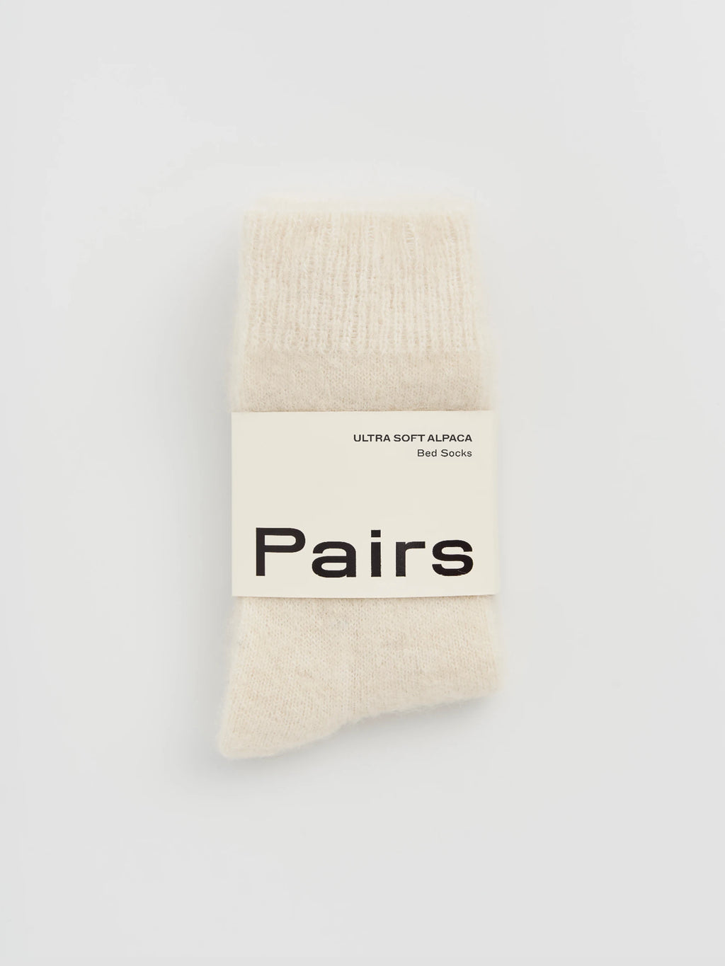 cream alpaca socks with 'Pairs' label 