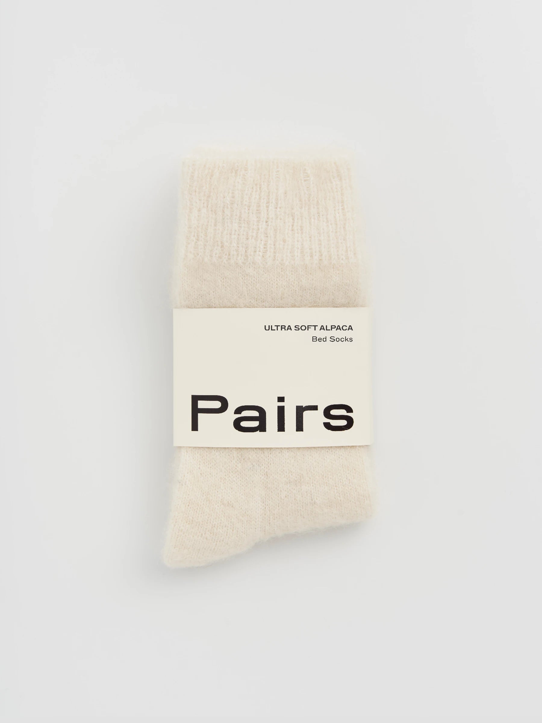 cream alpaca socks with 'Pairs' label 