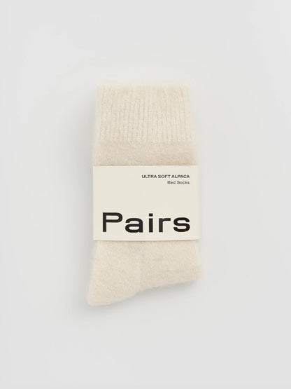 cream alpaca socks with 'Pairs' label 