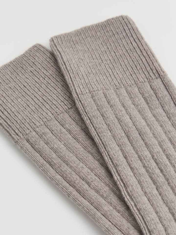 Gray ribbed knit merino socks on a white background