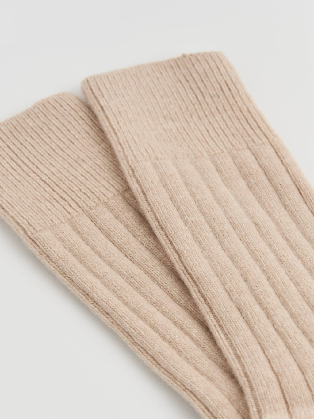 Beige ribbed knit socks on a light gray background