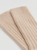 Beige ribbed knit socks on a light gray background