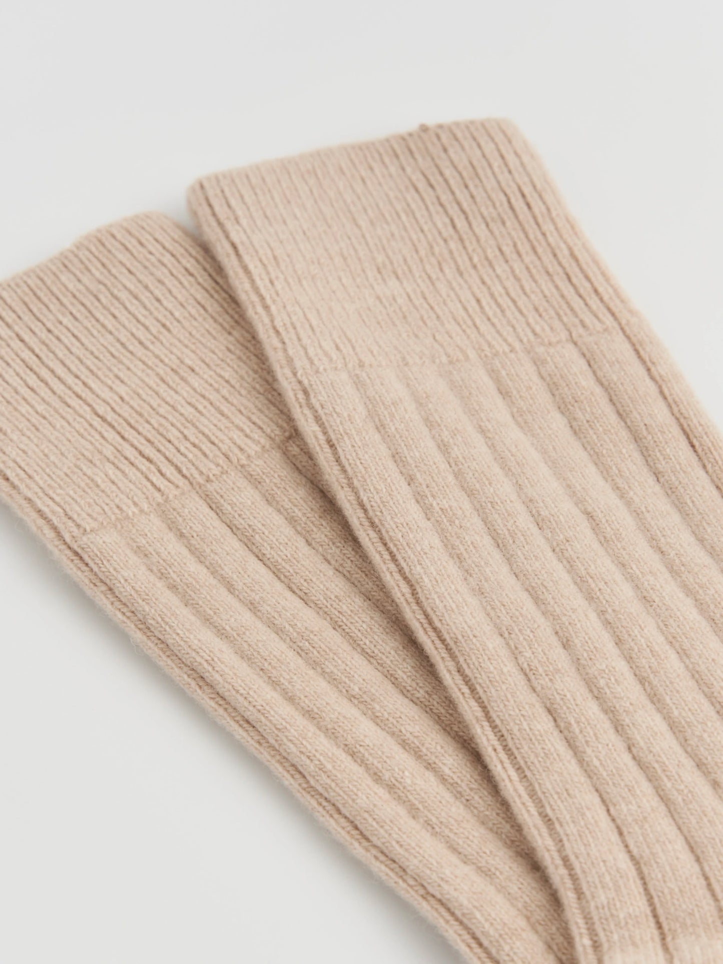 Beige ribbed knit socks on a light gray background