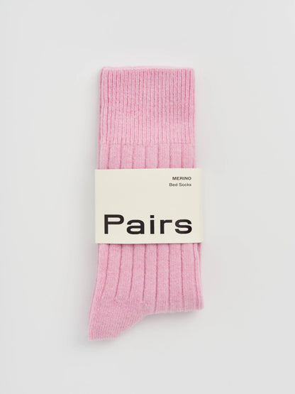 Pink socks with a 'Pairs' label on a light gray background