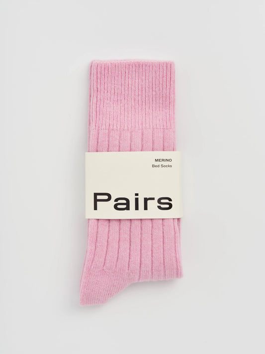 Pink socks with a 'Pairs' label on a light gray background