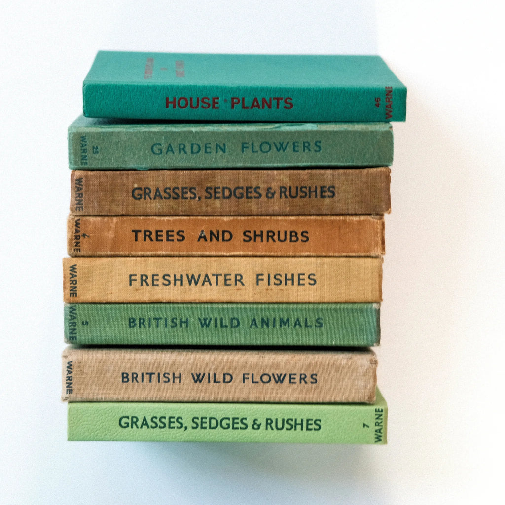 Stack of books on natural history topics with colored spines.
