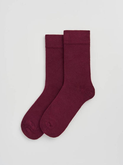 Pair of burgundy socks on a light gray background