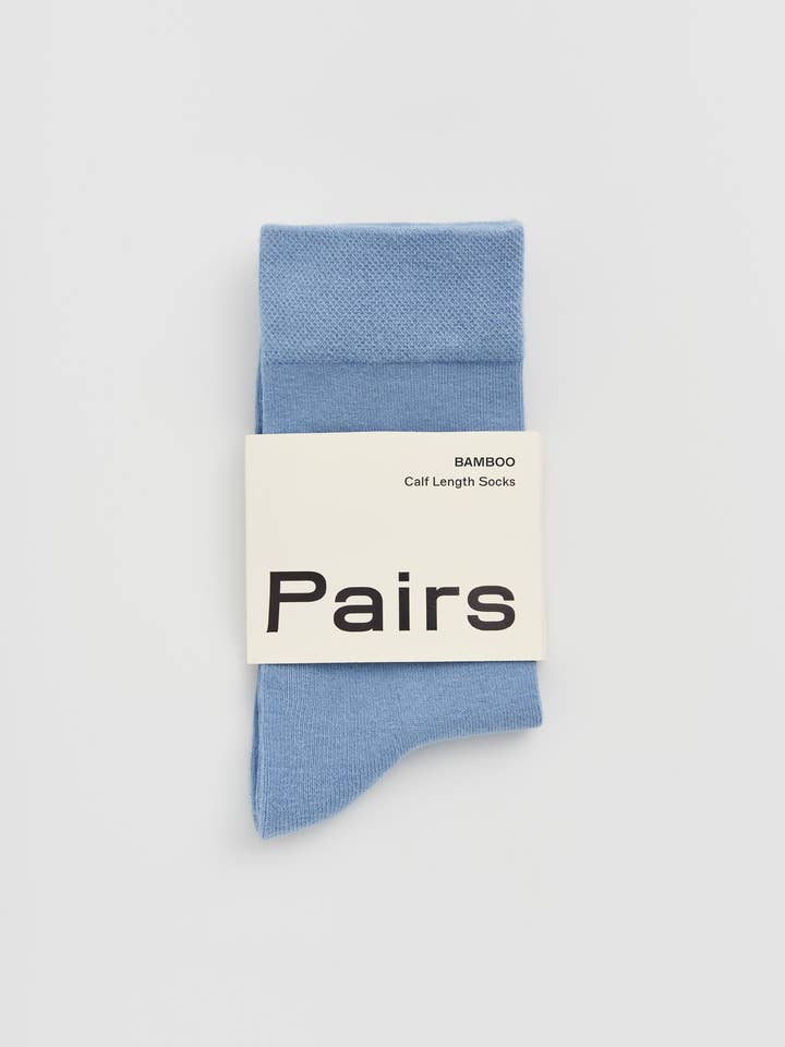 Blue sock with 'Pairs' packaging on a light gray background