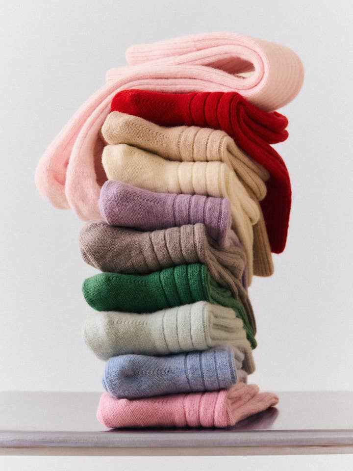Stack of colourful socks on a white surface