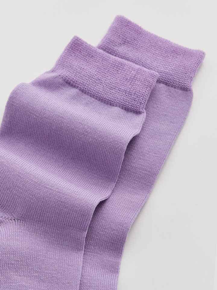 Set of purple socks on a light gray background