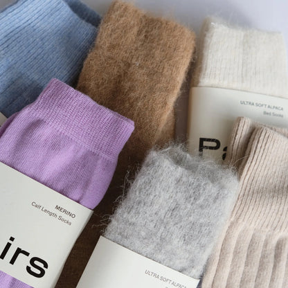 Collection of various colored socks with labels on a white background