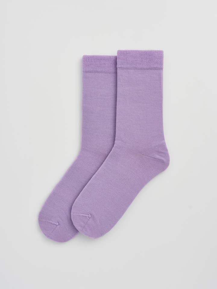Pair of purple socks on a light gray background