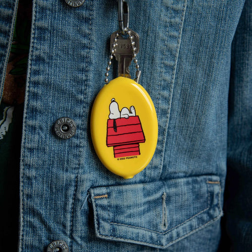 Yellow keychain with Snoopy design attached to a denim jacket