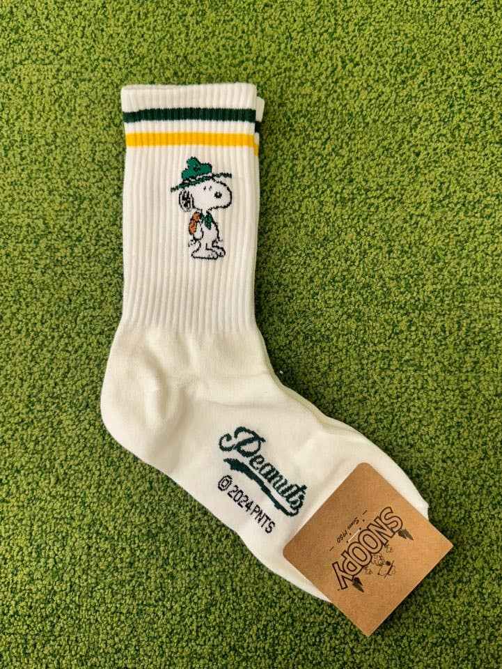 White sock with a snoopy character on a green textured background