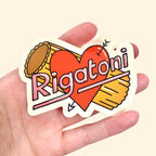 Sticker with heart and rigatoni pasta held in a hand against a beige background