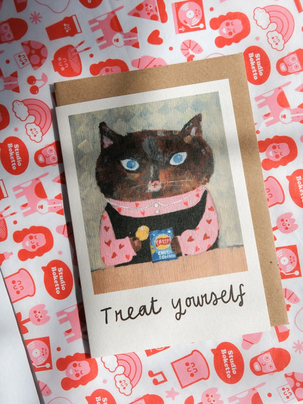 Card with a cat illustration and 'Treat yourself' text on a patterned background