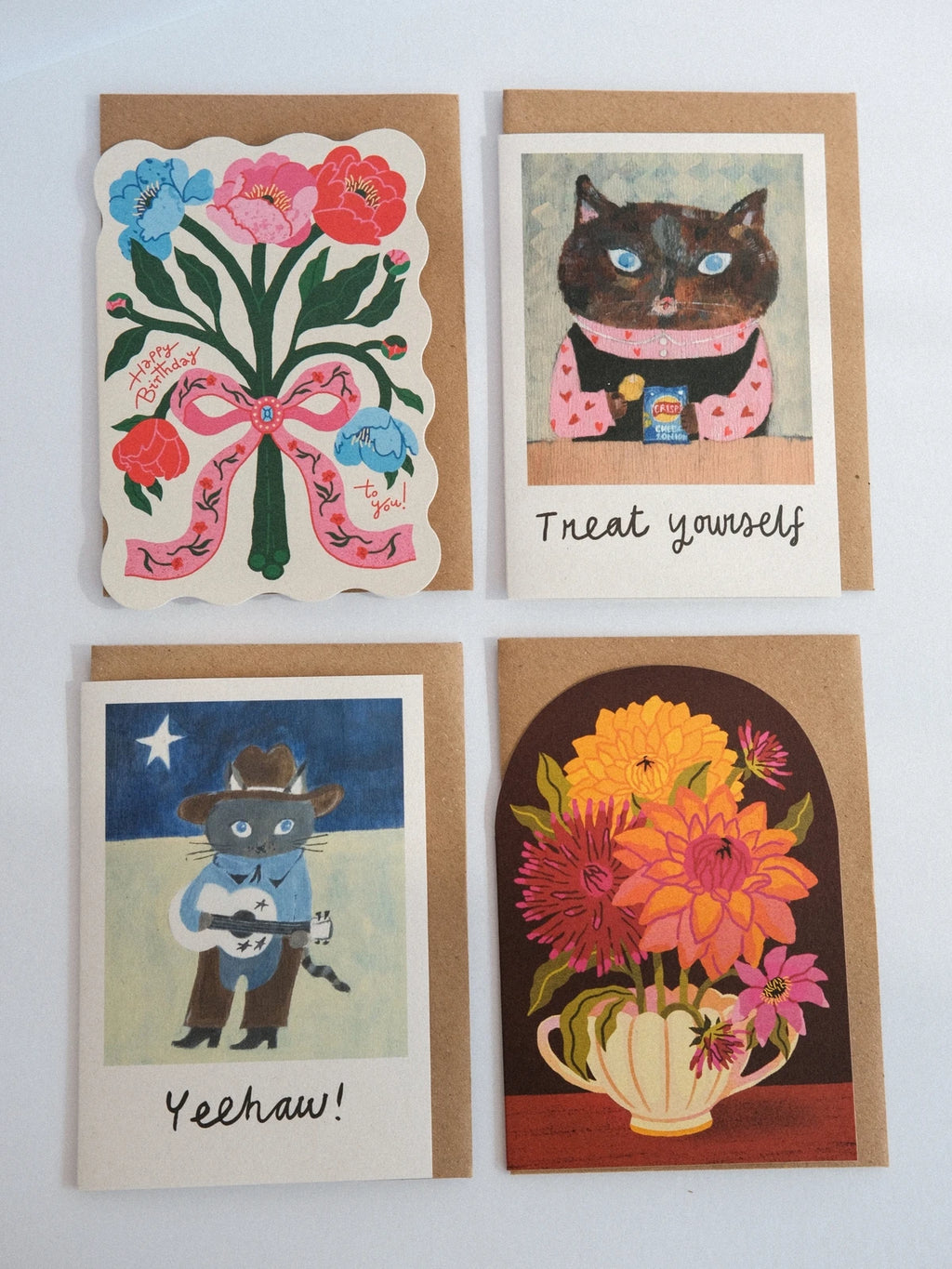 Four greeting cards with different designs on a white background