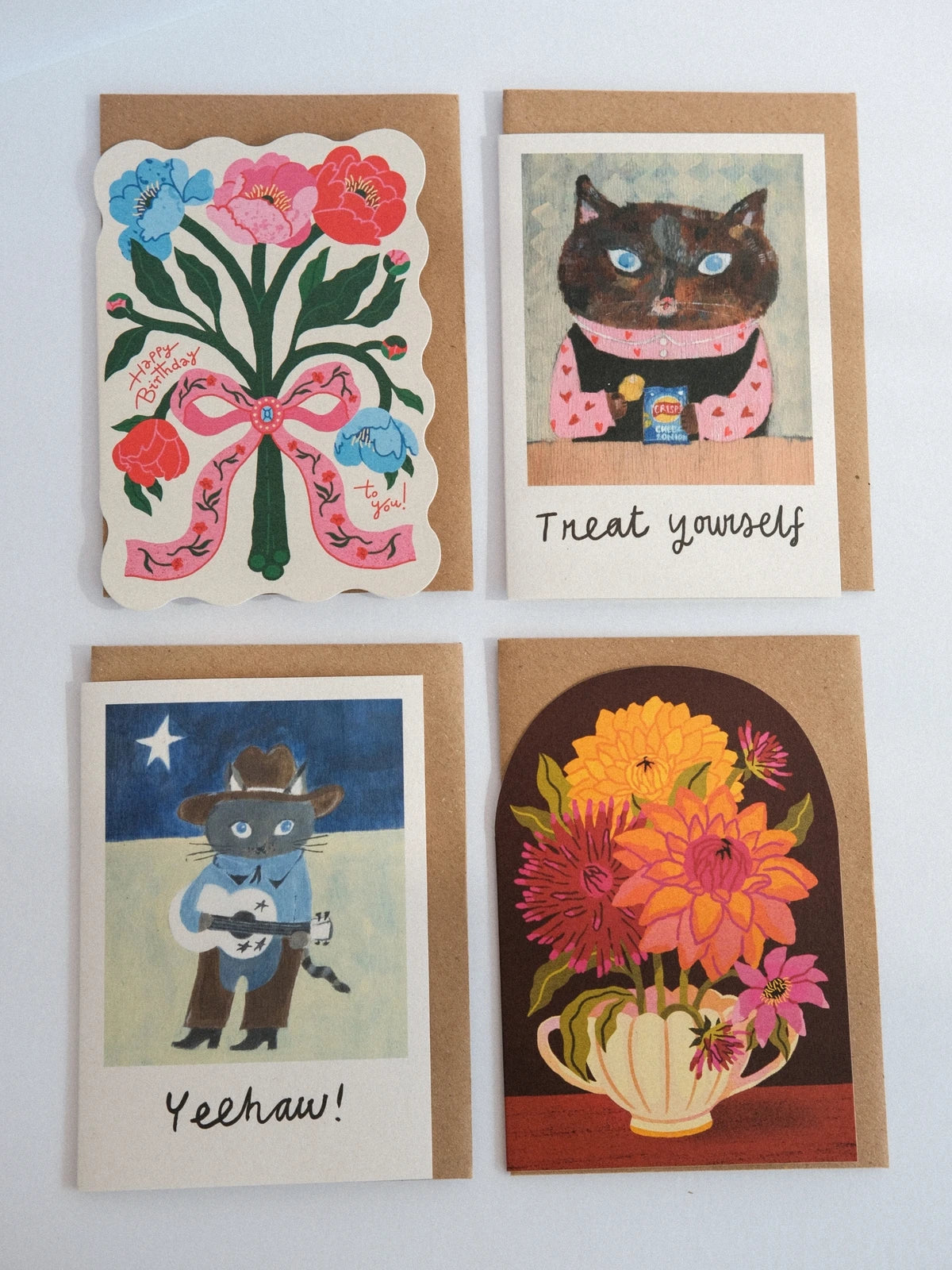 Four greeting cards with different designs on a white background