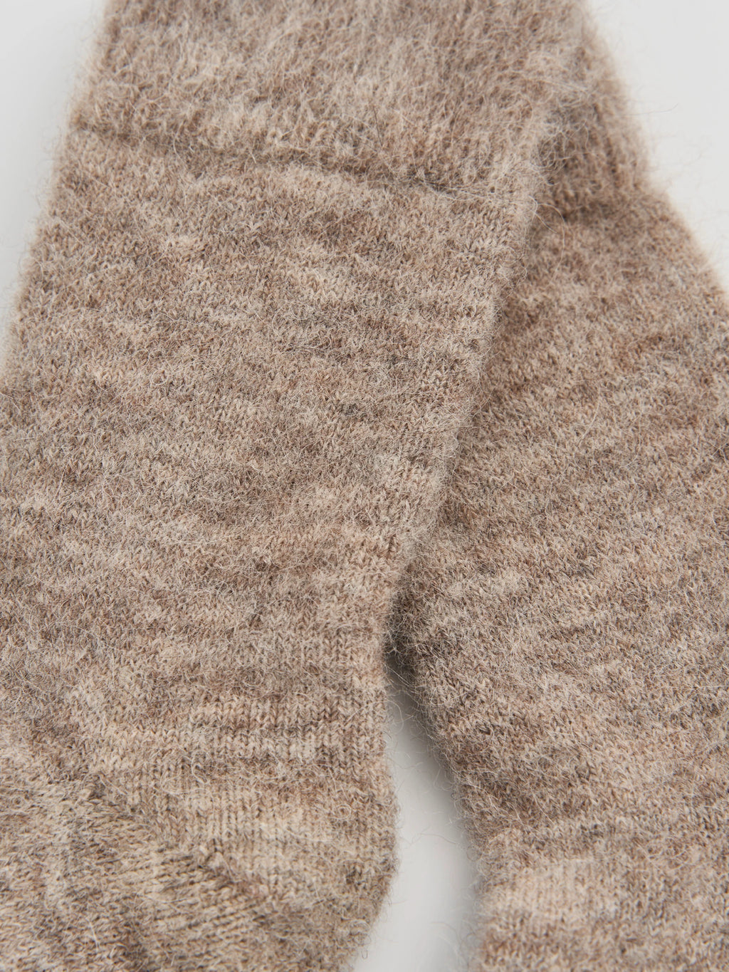 Close-up of a brown knitted sock on a white background