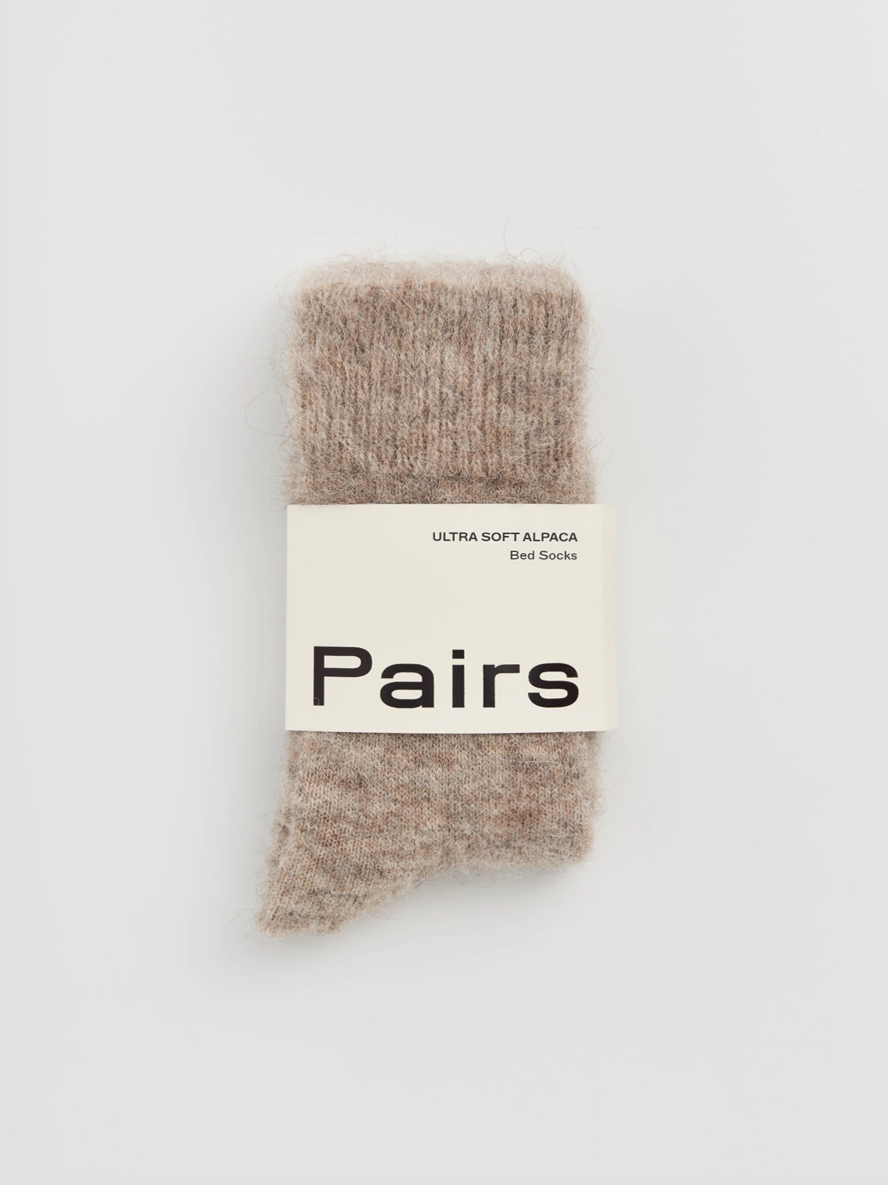 Pair of beige socks with a 'Pairs' label on a white background